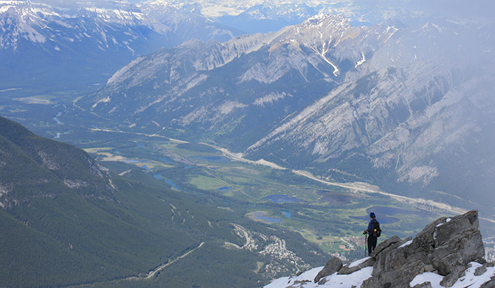 A person looks down on a mountain valley