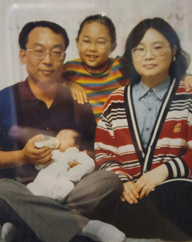 A family photo of four people taken in the 1990s