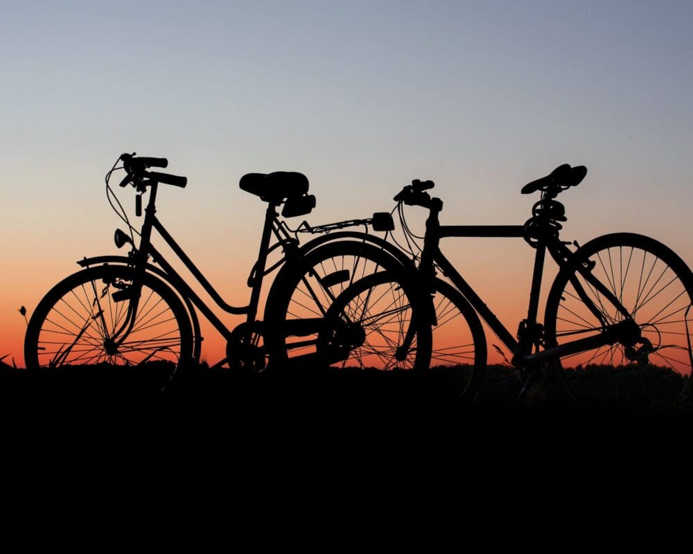Silhouetted bicycles against a sunset